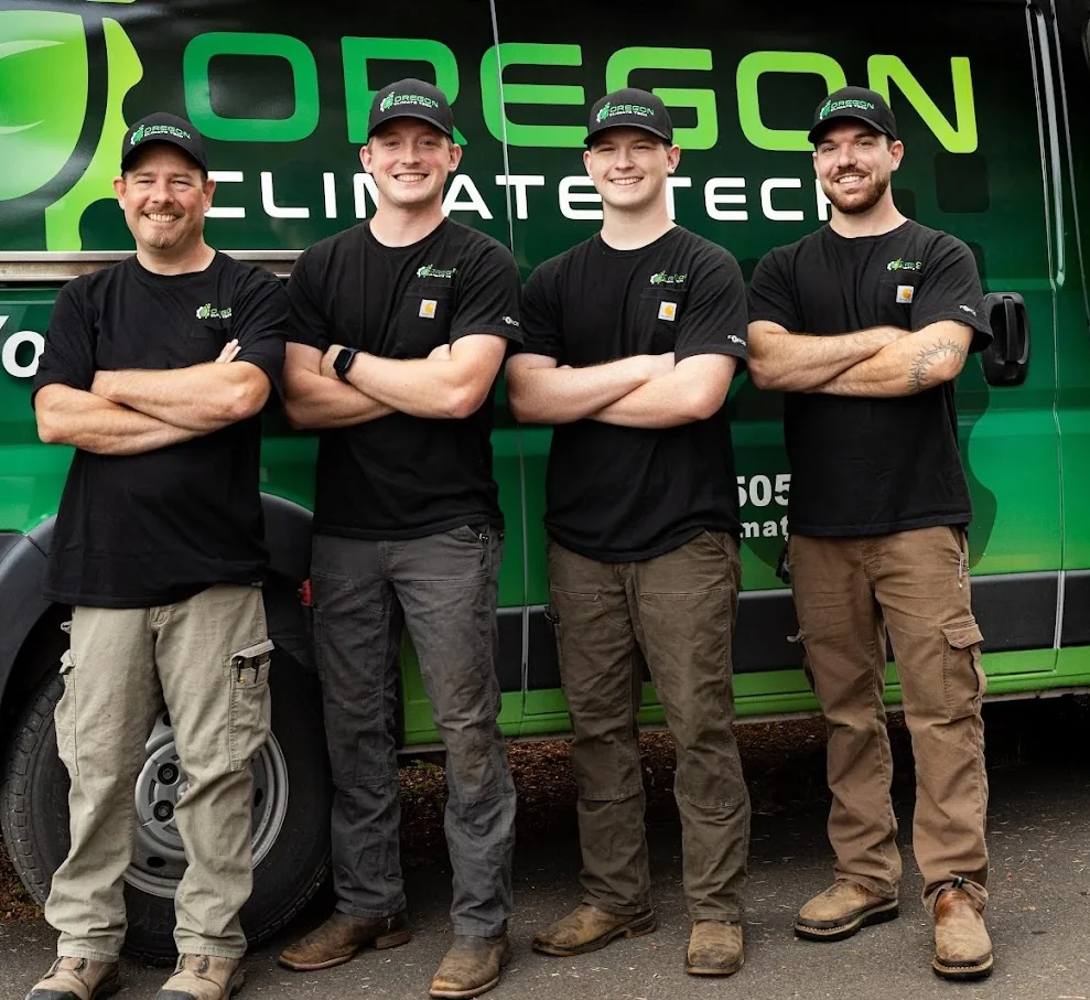 Four local service technicians standing beside a green work van